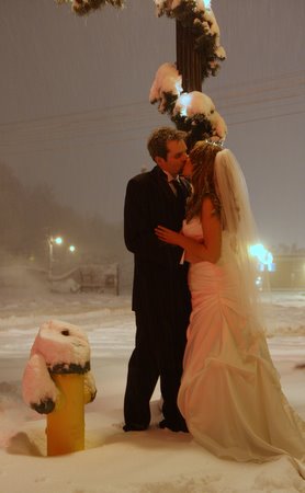 Luke and Lindsay kiss in the snow on their wedding day.